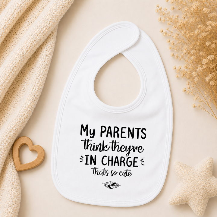 Wit baby slabbetje met tekst “My parents think they’re in charge, that’s so cute” – slab met tekst voor baby