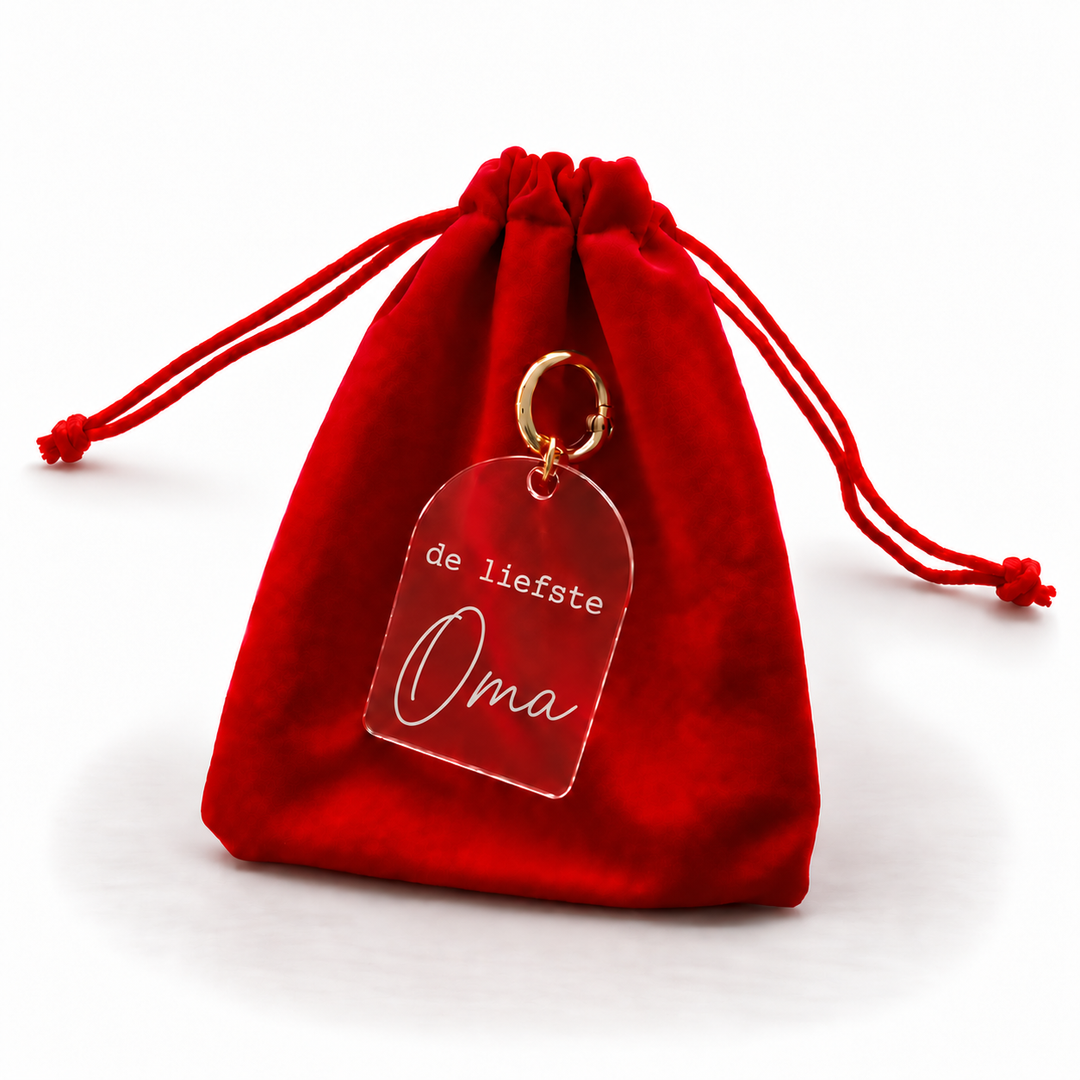 Persoonlijke sleutelhanger met tekst de liefste oma aan rood cadeauzakje.