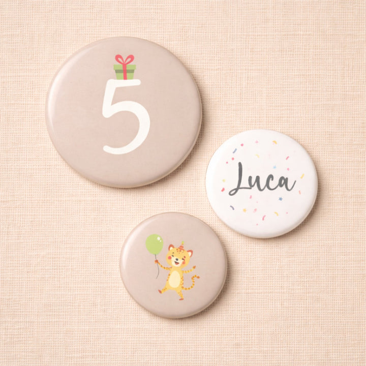 Set van drie gepersonaliseerde verjaardagsbuttons voor een 5e verjaardag met het getal 5, de naam Luca en een vrolijke tijgerillustratie, uitgevoerd in zachte neutrale tinten.