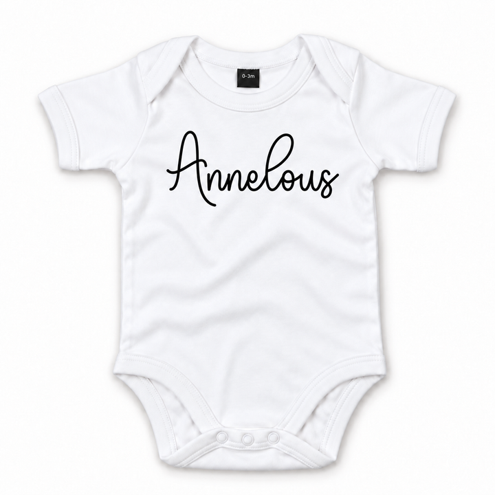 Witte baby romper met naam Annelous in zwart sierlijk schrift.