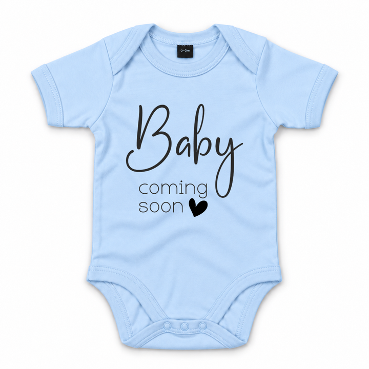 Blauwe zwangerschapsaankondiging romper met zwarte tekst Baby Coming Soon.