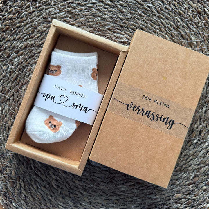 Cadeaudoosje met babysokjes voor originele zwangerschapsaankondiging aan opa en oma of oom en tante
