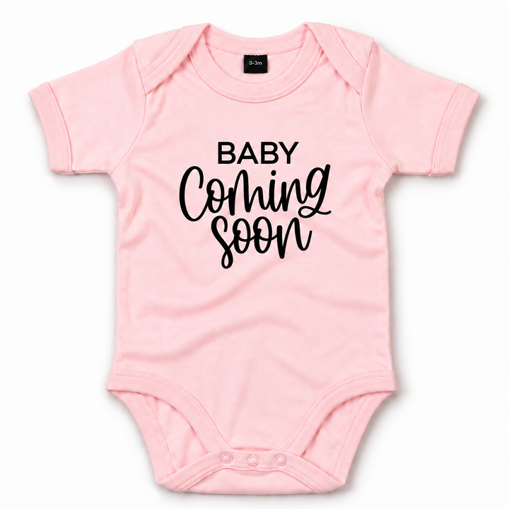 Roze Baby Coming Soon romper zonder jaartal.