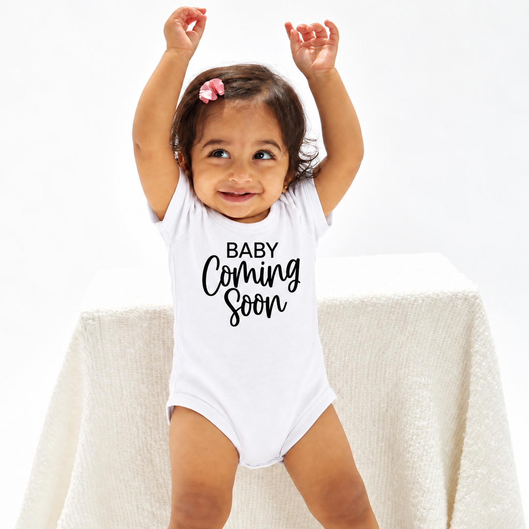 Baby in wit Baby Coming Soon rompertje met jaartal.
