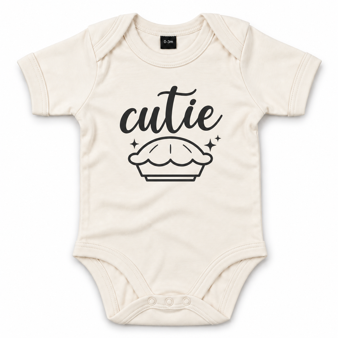 Naturel babyrompertje met opdruk Cutie en taartje op witte achtergrond