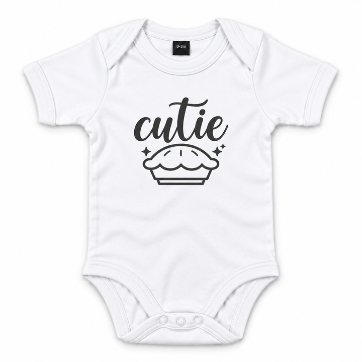 Wit babyrompertje met tekst Cutie en taartillustratie in zwart