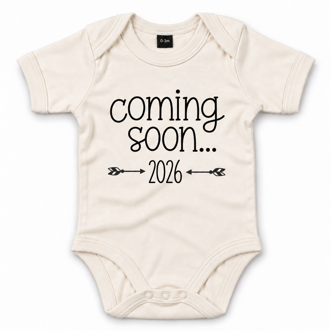 Naturel Coming Soon romper met jaartal en pijltjes.