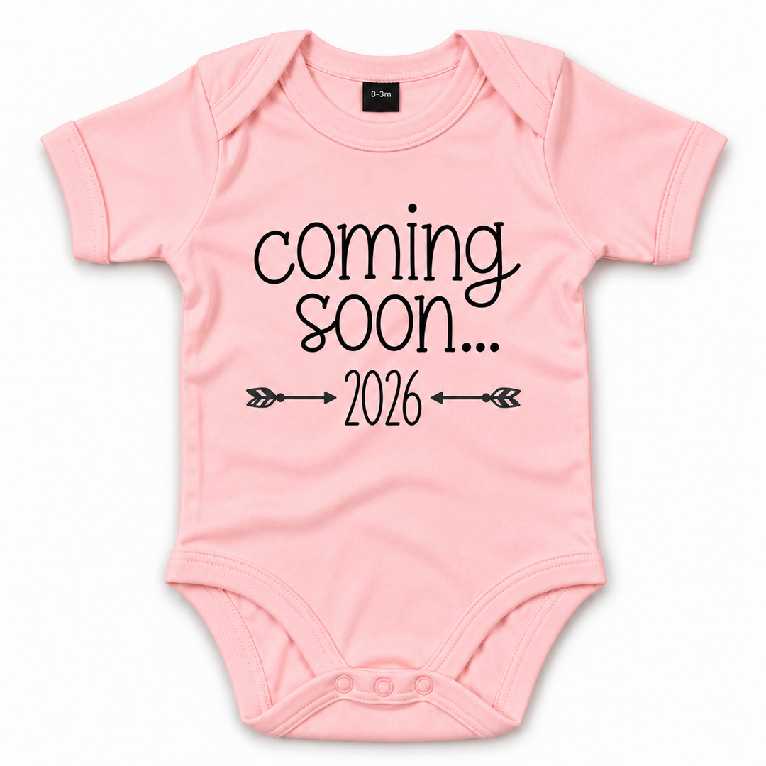 Roze Coming Soon romper met jaartal en pijltjes.