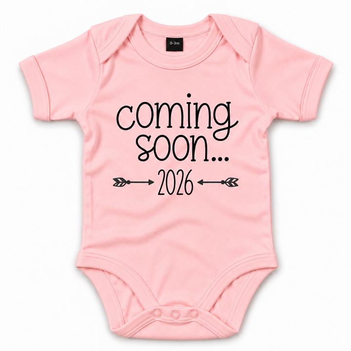 Roze Coming Soon romper met jaartal en pijltjes.