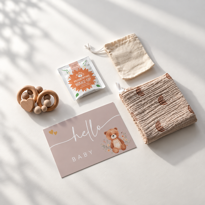 Beige kraamcadeauset met houten bijtring, hydrofiele doek met regenboogprint, thee, cadeaukaart en katoenen zakje.