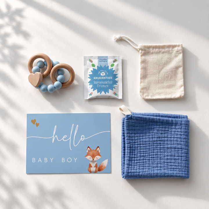 Blauwe kraamcadeauset voor baby boy van bovenaf met houten bijtring, hydrofiele doek, thee, cadeaukaart en katoenen zakje.