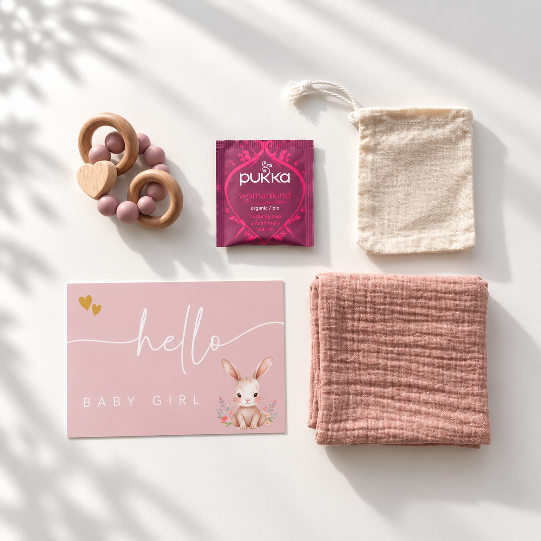 Roze kraamcadeauset voor baby girl met bijtring, hydrofiele doek, thee, cadeaukaart en katoenen zakje.