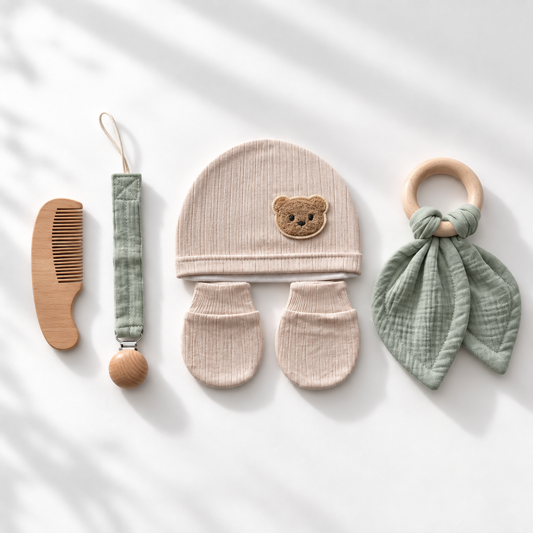 Baby kraamcadeauset met beige muts en wantjes, houten kam, speenkoord en groene bijtring.
