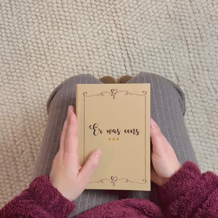 Video van originele zwangerschapsaankondiging aan opa en oma waarbij het boekje wordt geopend en de inhoud zichtbaar is met echofoto, zwangerschapstest en tutteldoekje BAMBAM