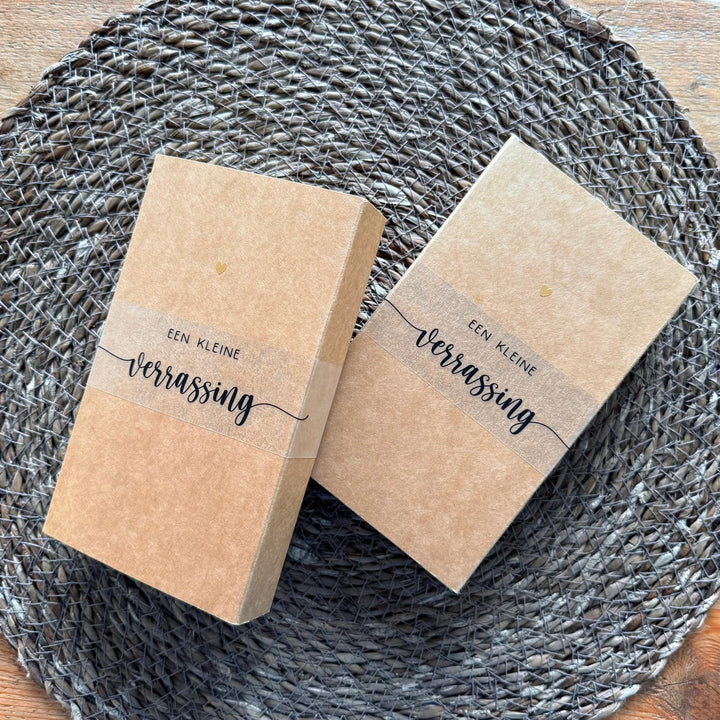 Kraft cadeauverpakking voor zwangerschapsaankondiging met babysokjes