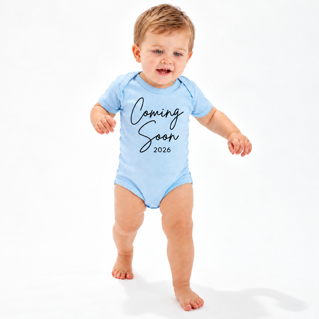 Blauw zwangerschapsaankondiging rompertje met Coming Soon 2026 gedragen door baby.